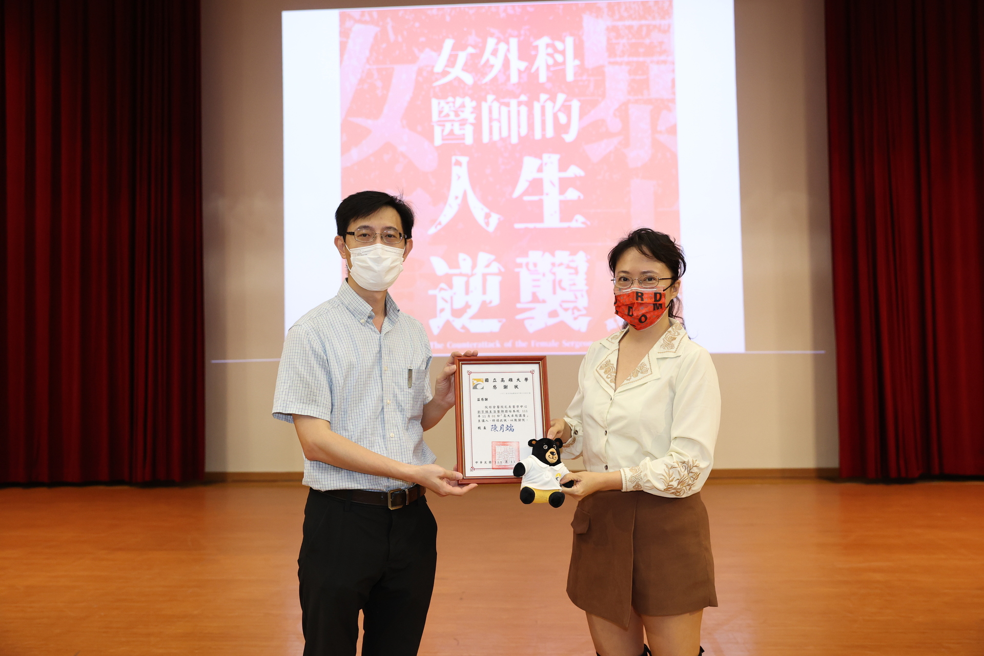 高雄大學推教中心主任余進忠（左）代表校方辦贈感謝狀予「小劉醫師」劉宗瑀。