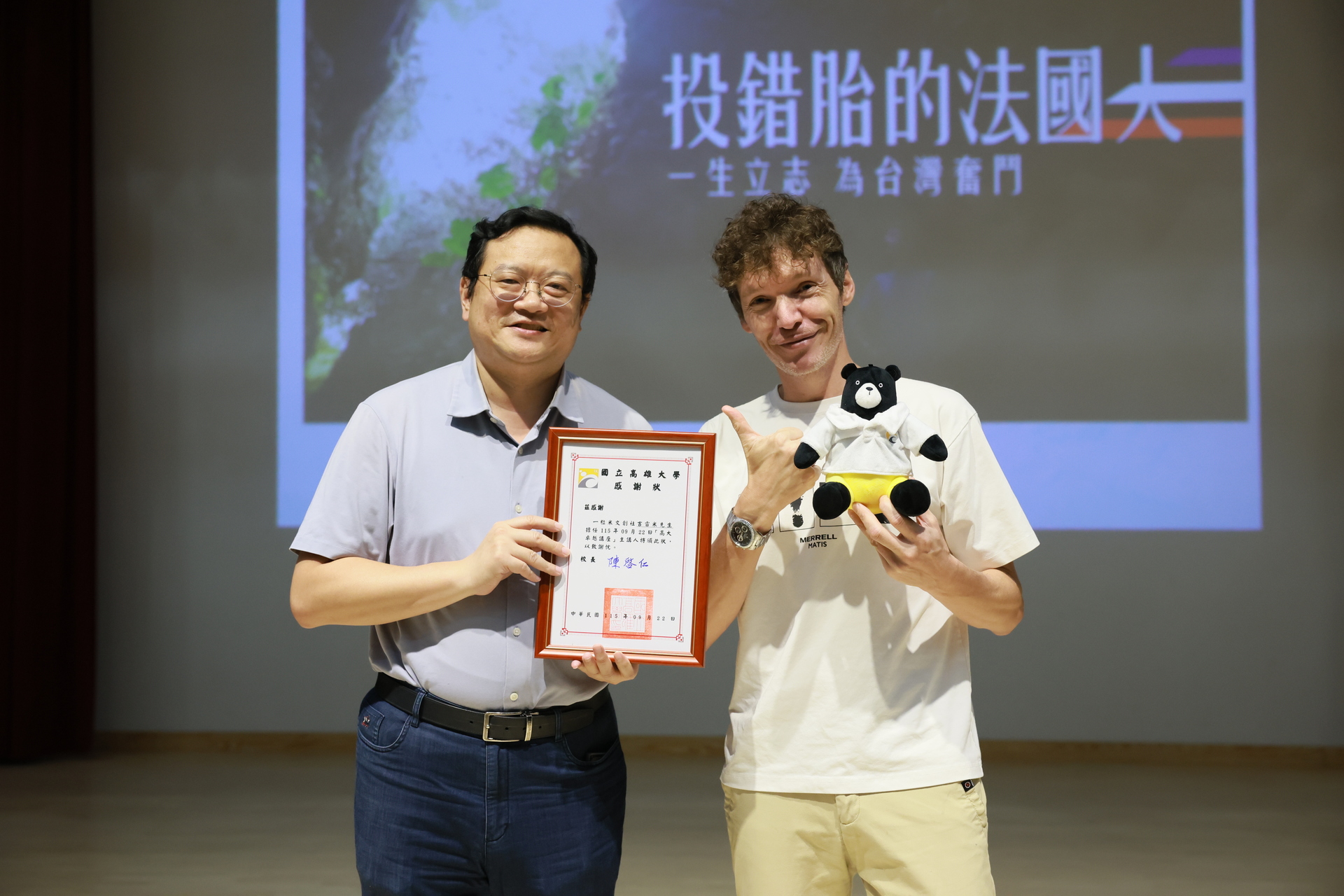 高雄大學行政副校長吳行浩（左）頒贈感謝狀予「一粒米」吉雷米，感謝蒞校演講。