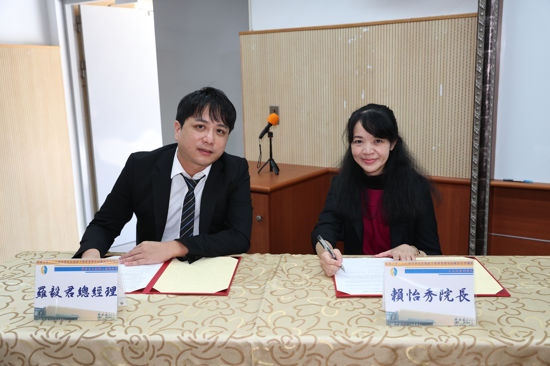 高雄大學人社院院長賴怡秀（右）、與校友羅毅君簽署捐助合約