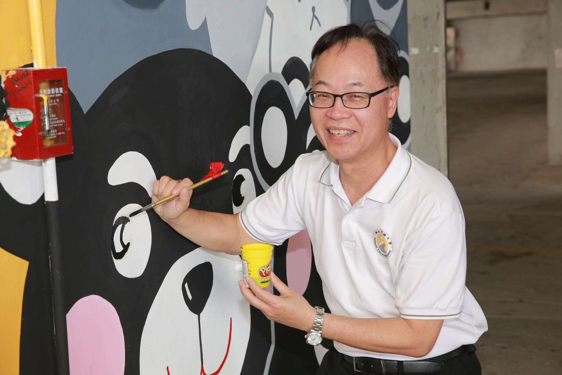 校長王學亮為「群熊共舞」壁畫彩繪畫熊點睛