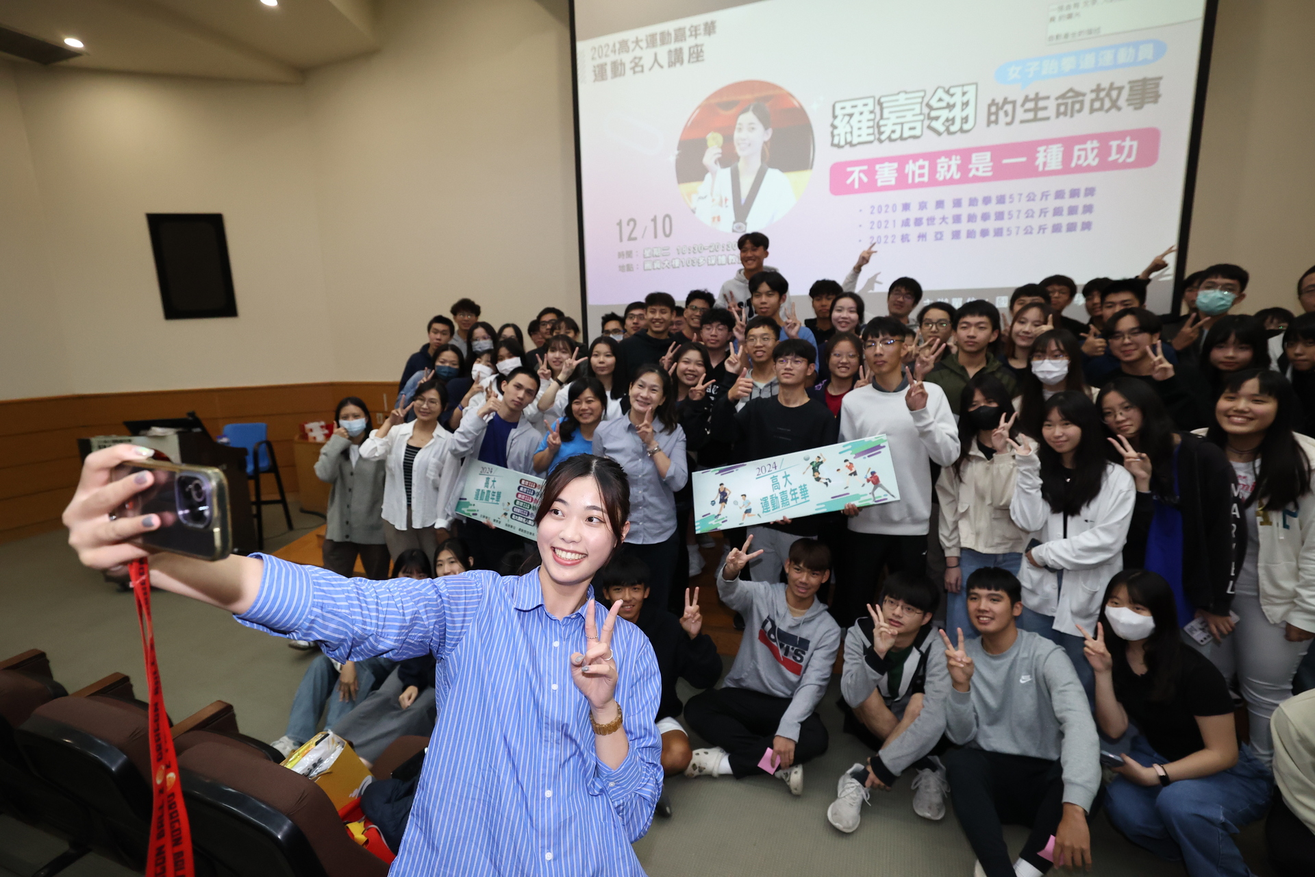 跆拳道國手羅嘉翎（手持手機者）應邀出席體育室運動嘉年華《名人講座》暨閉幕典禮，與師生自拍合影。