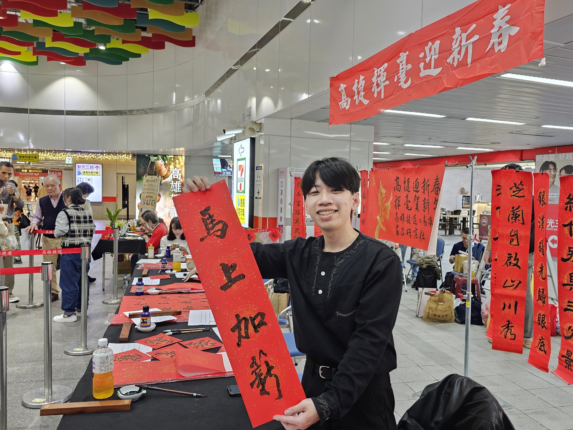 國立高雄大學師生攜手高雄捷運公司、蚵子寮通安宮與藍田里仁壽宮舉辦「揮毫贈春聯」活動，走入場站與社區，傳遞馬年新春祝福。002圖片