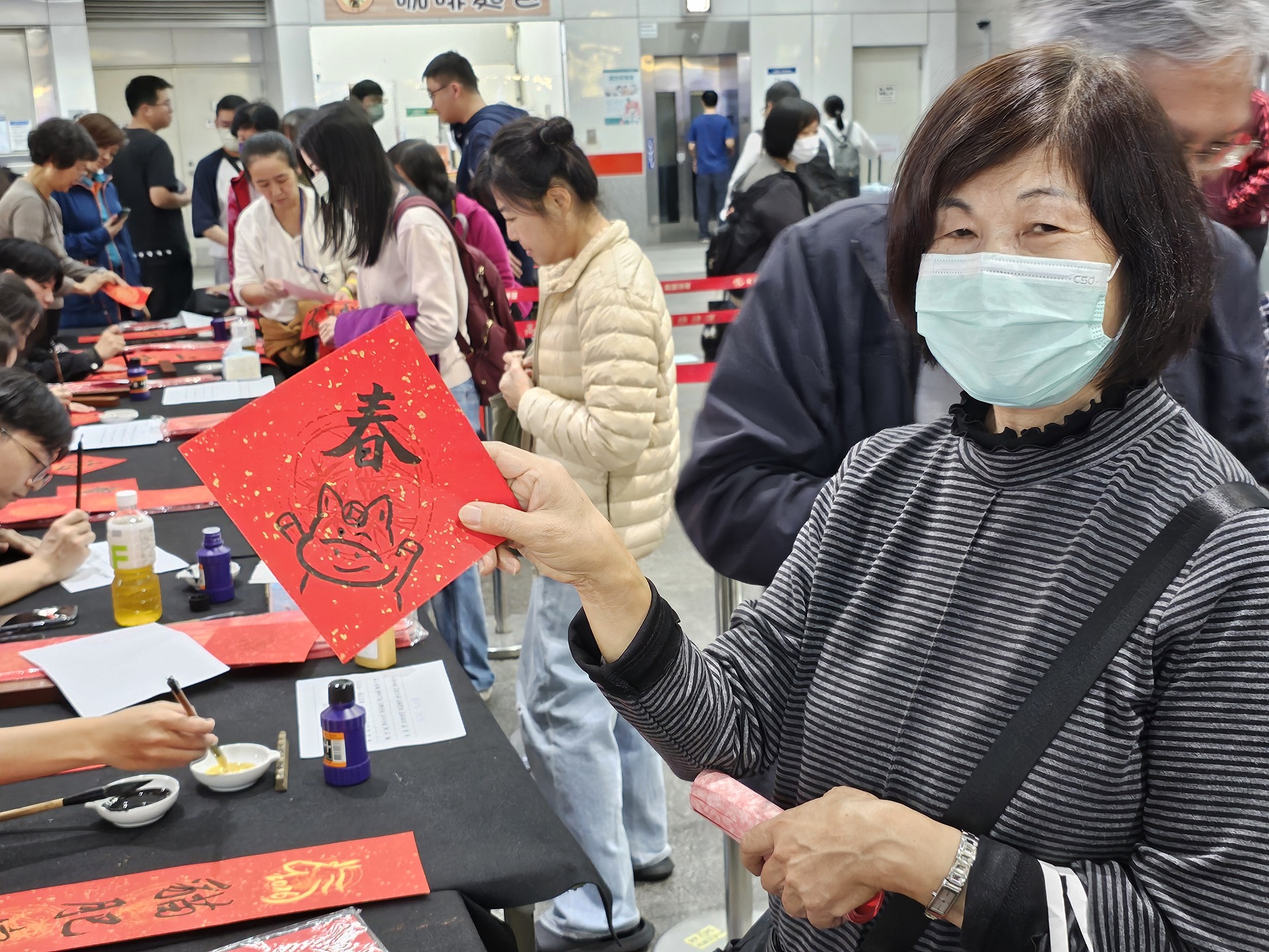 國立高雄大學師生攜手高雄捷運公司、蚵子寮通安宮與藍田里仁壽宮舉辦「揮毫贈春聯」活動，走入場站與社區，傳遞馬年新春祝福。008圖片