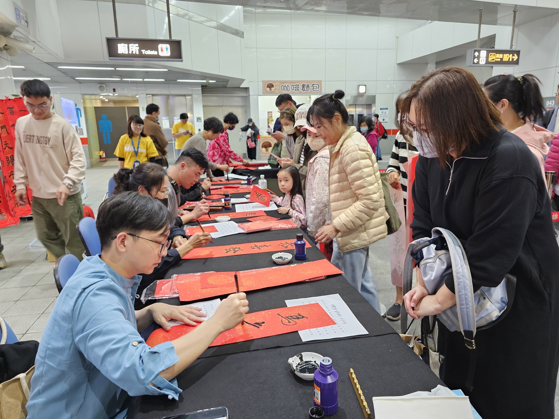 國立高雄大學師生攜手高雄捷運公司、蚵子寮通安宮與藍田里仁壽宮舉辦「揮毫贈春聯」活動，走入場站與社區，傳遞馬年新春祝福。012圖片