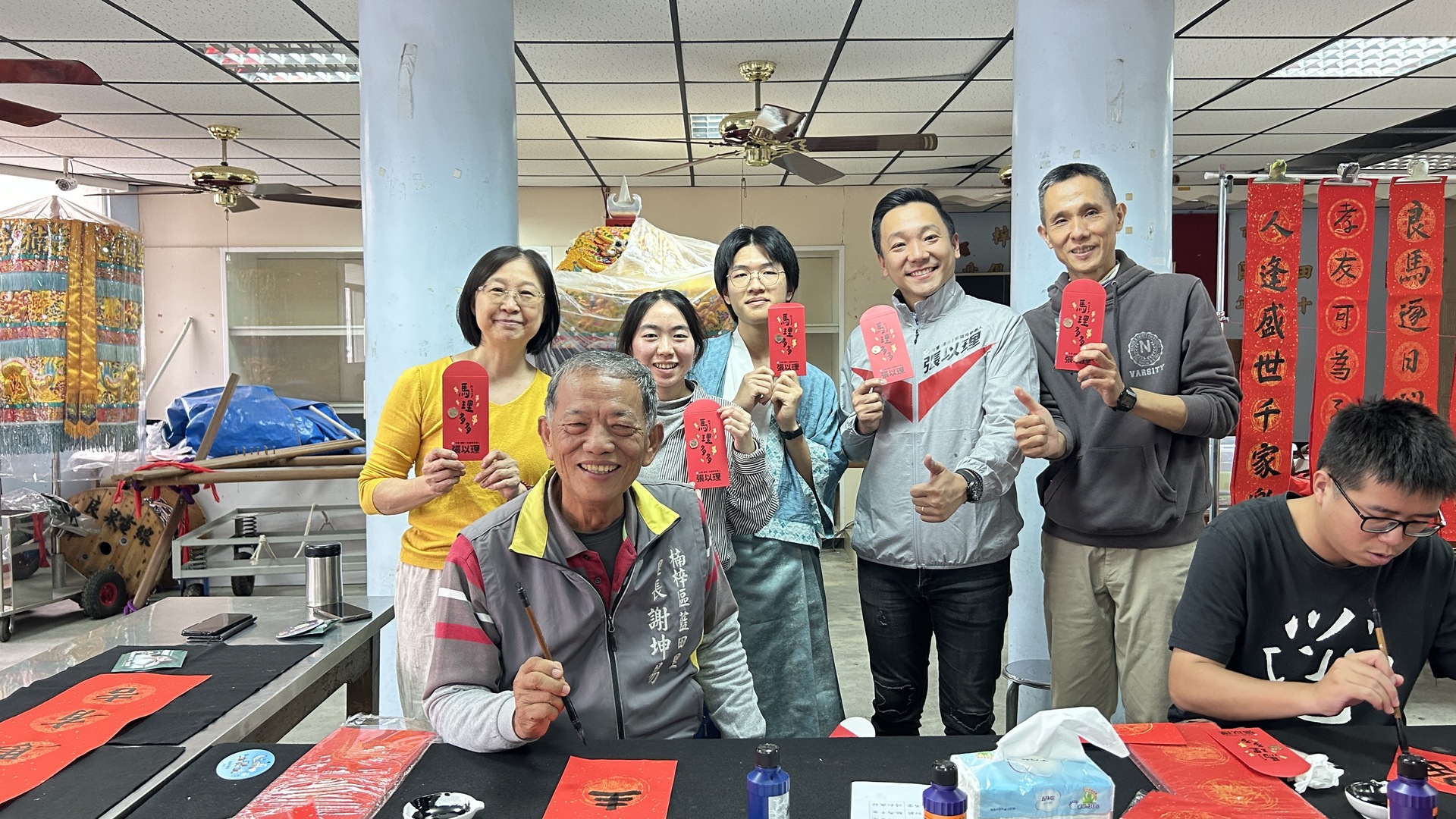 國立高雄大學師生攜手高雄捷運公司、蚵子寮通安宮與藍田里仁壽宮舉辦「揮毫贈春聯」活動，走入場站與社區，傳遞馬年新春祝福。020圖片