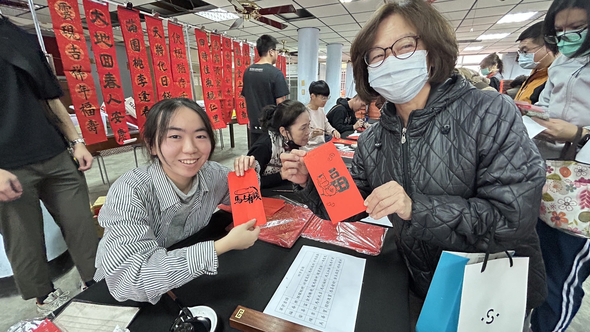 國立高雄大學師生攜手高雄捷運公司、蚵子寮通安宮與藍田里仁壽宮舉辦「揮毫贈春聯」活動，走入場站與社區，傳遞馬年新春祝福。023圖片
