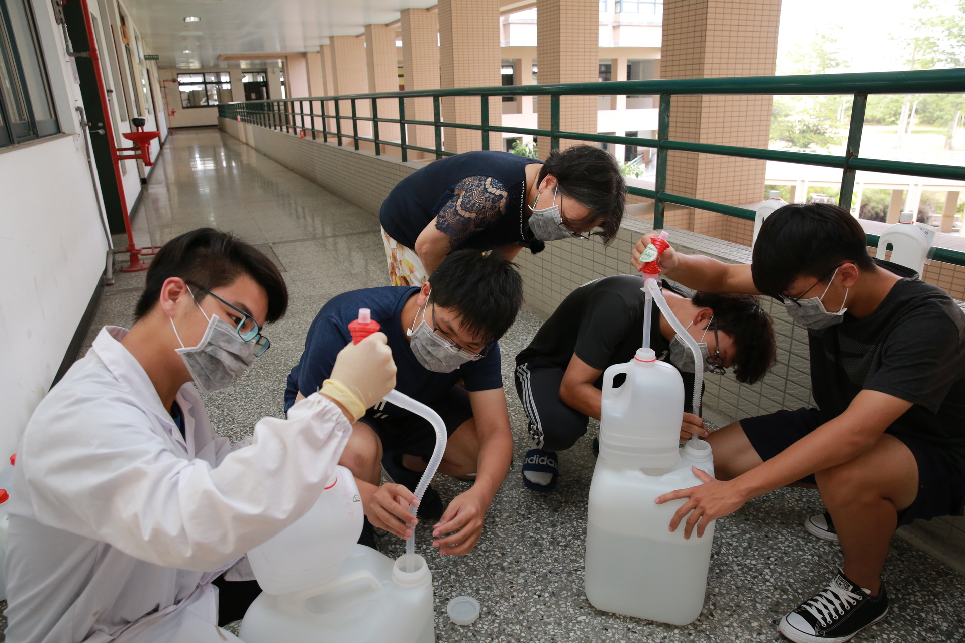 應用化學系師生發揮所學，分別調配消毒酒精、消毒水，運送至各學院、系所，用以清潔頻繁使用的教室課桌椅，加強公共衛生也減輕清潔人員負擔。