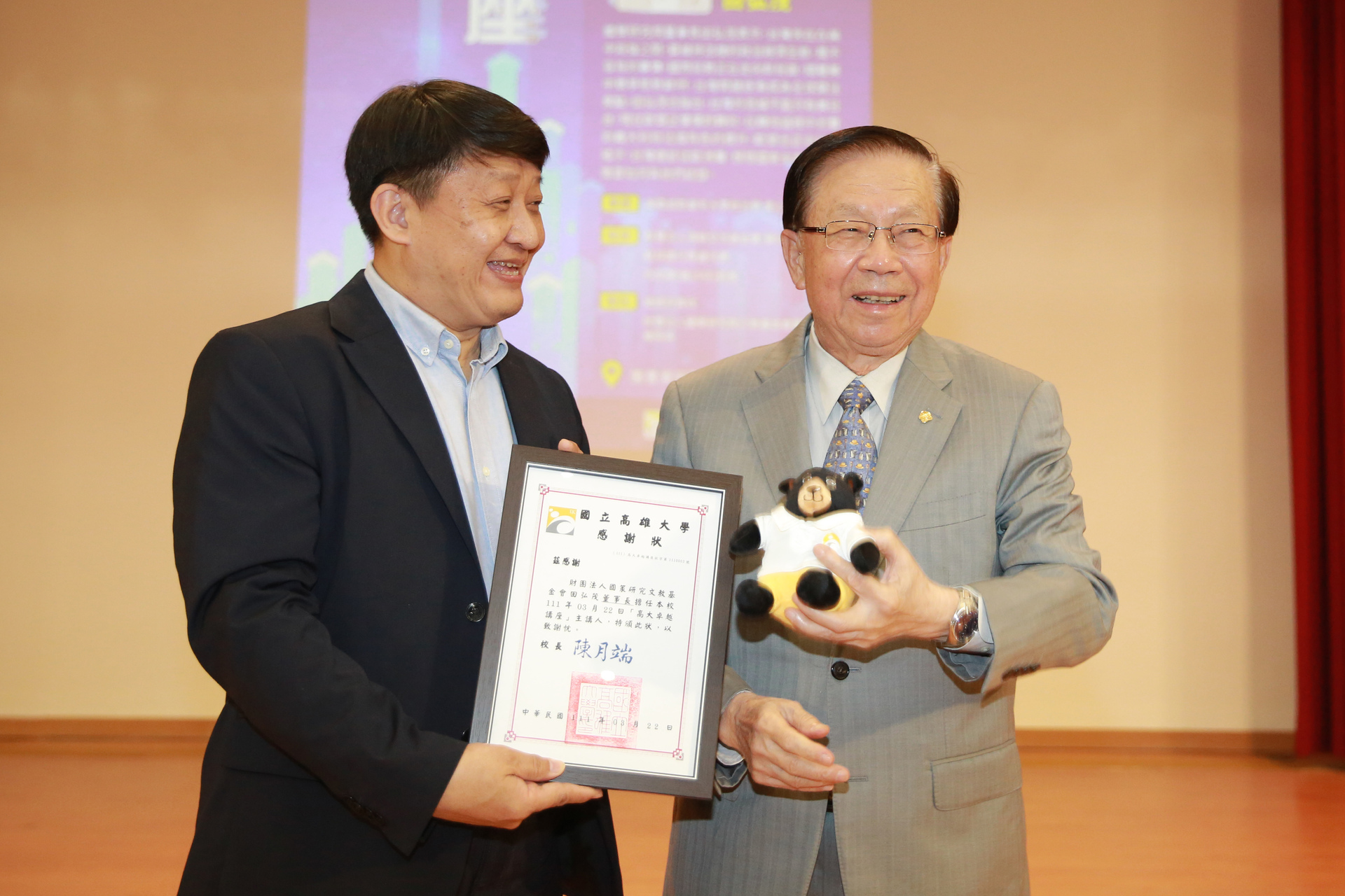 高雄大學學術副校長陳啓仁（左），代表校方頒贈感謝狀予財團法人國策研究院文教基金會院長田弘茂