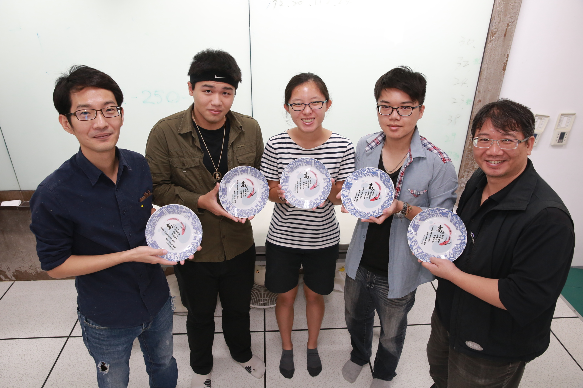 藝創系師生，左起：副教授王政弘、學生童秀祥、張茴釉、陳佑翔、系主任翁群儀，精心設計紀念盤。