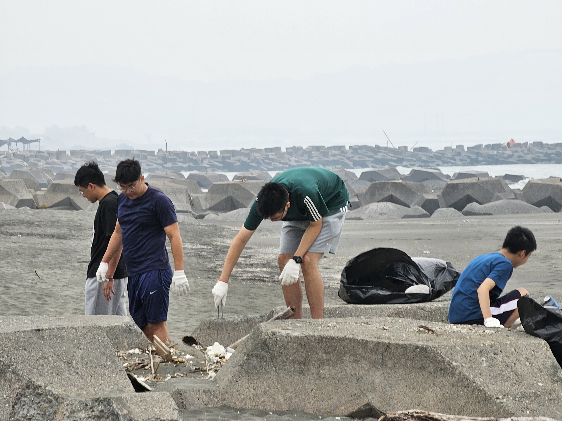 NUK's faculty and students collaborate with the local community to initiate the Kezailiao Beach cleanup. 012Image