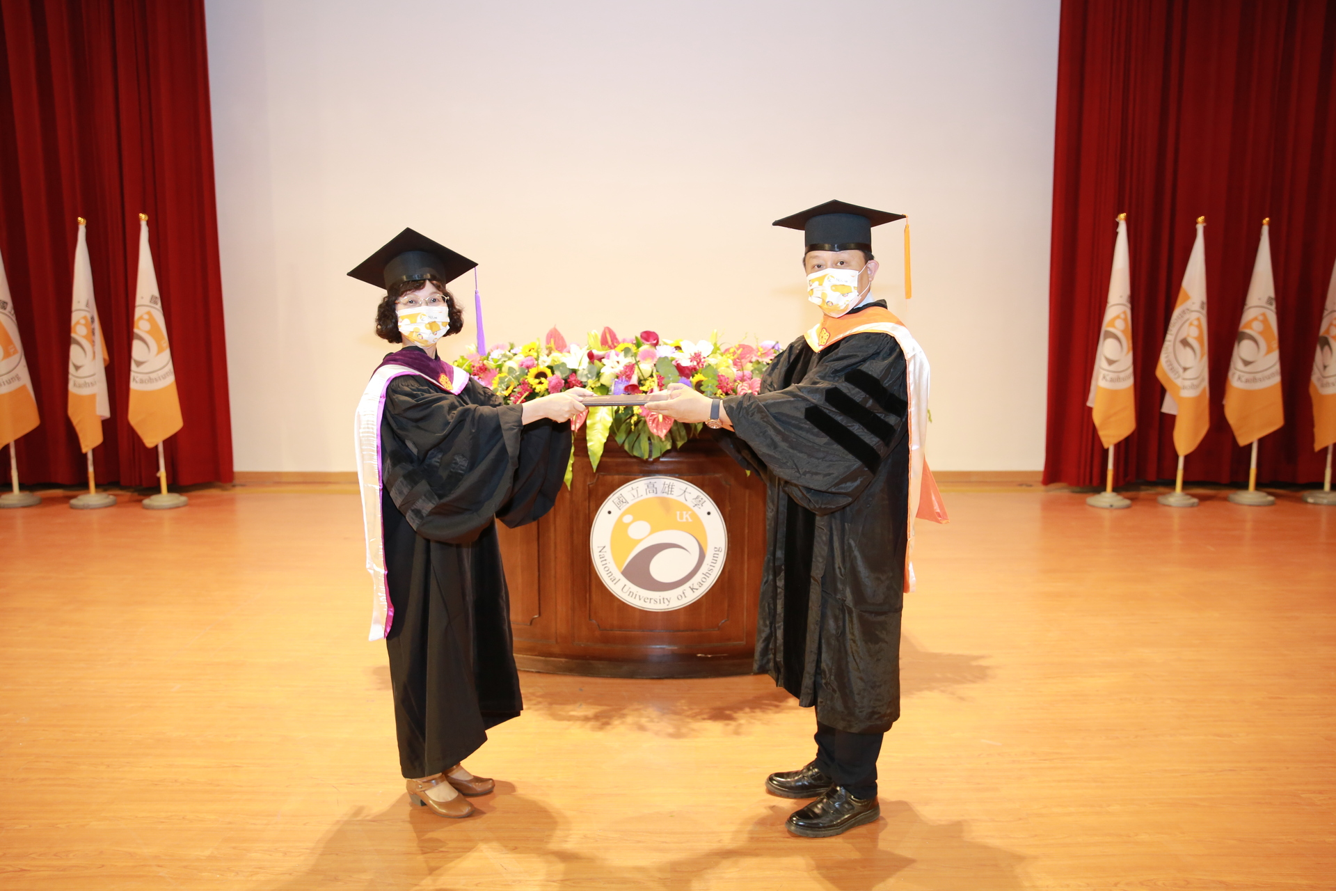 國立高雄大學教務長陳啓仁（右）向校長陳月端宣讀今年畢業生人數  
