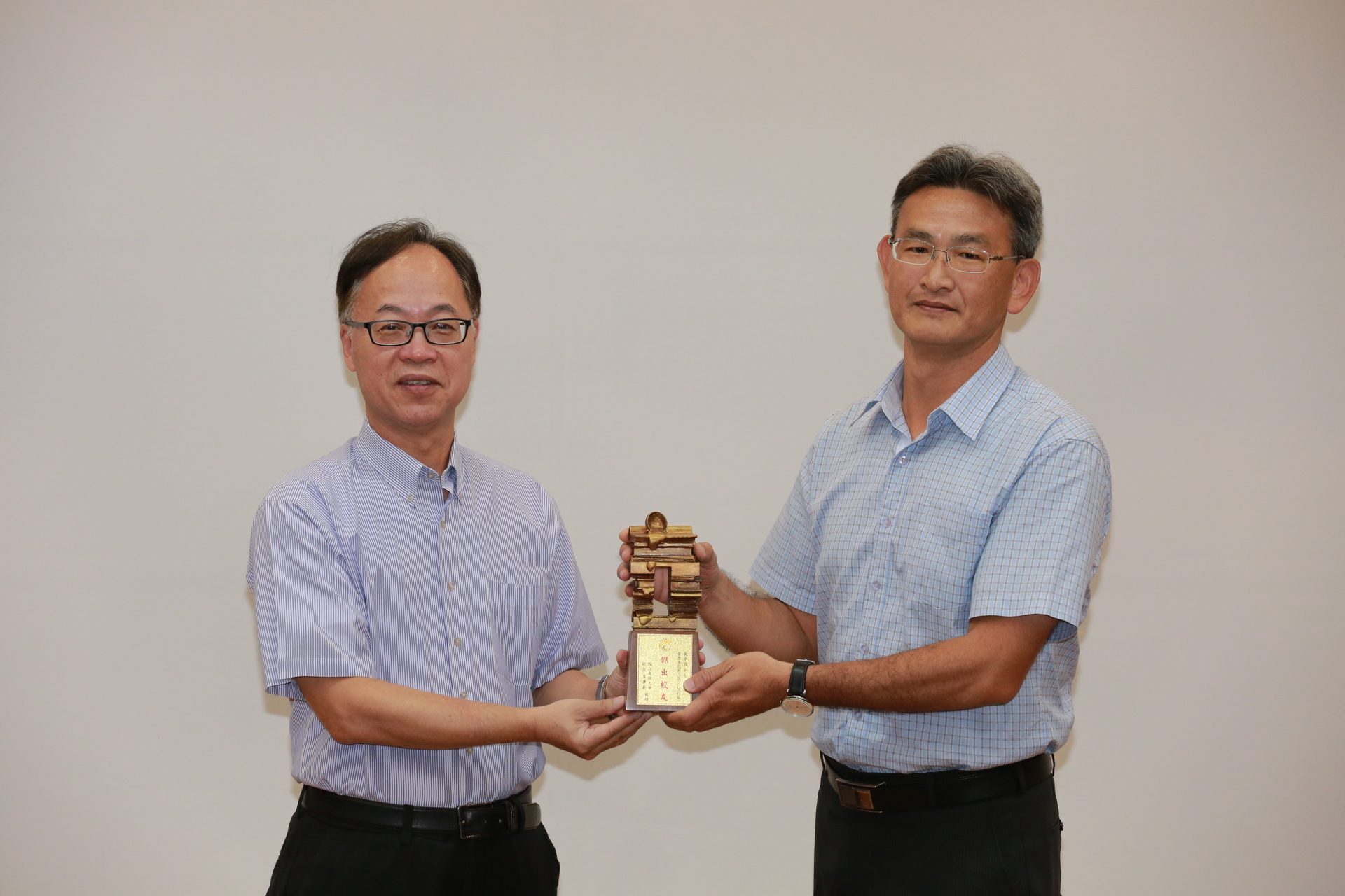 校長王學亮（左）頒發「第3屆傑出校友」榮銜予運健休系系友黃亭茵，由系主任張志成代領。