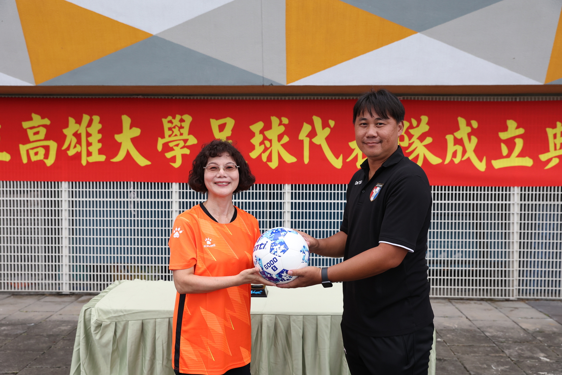 校長陳月端交付足球予總教練陳建志，以示成軍圖片