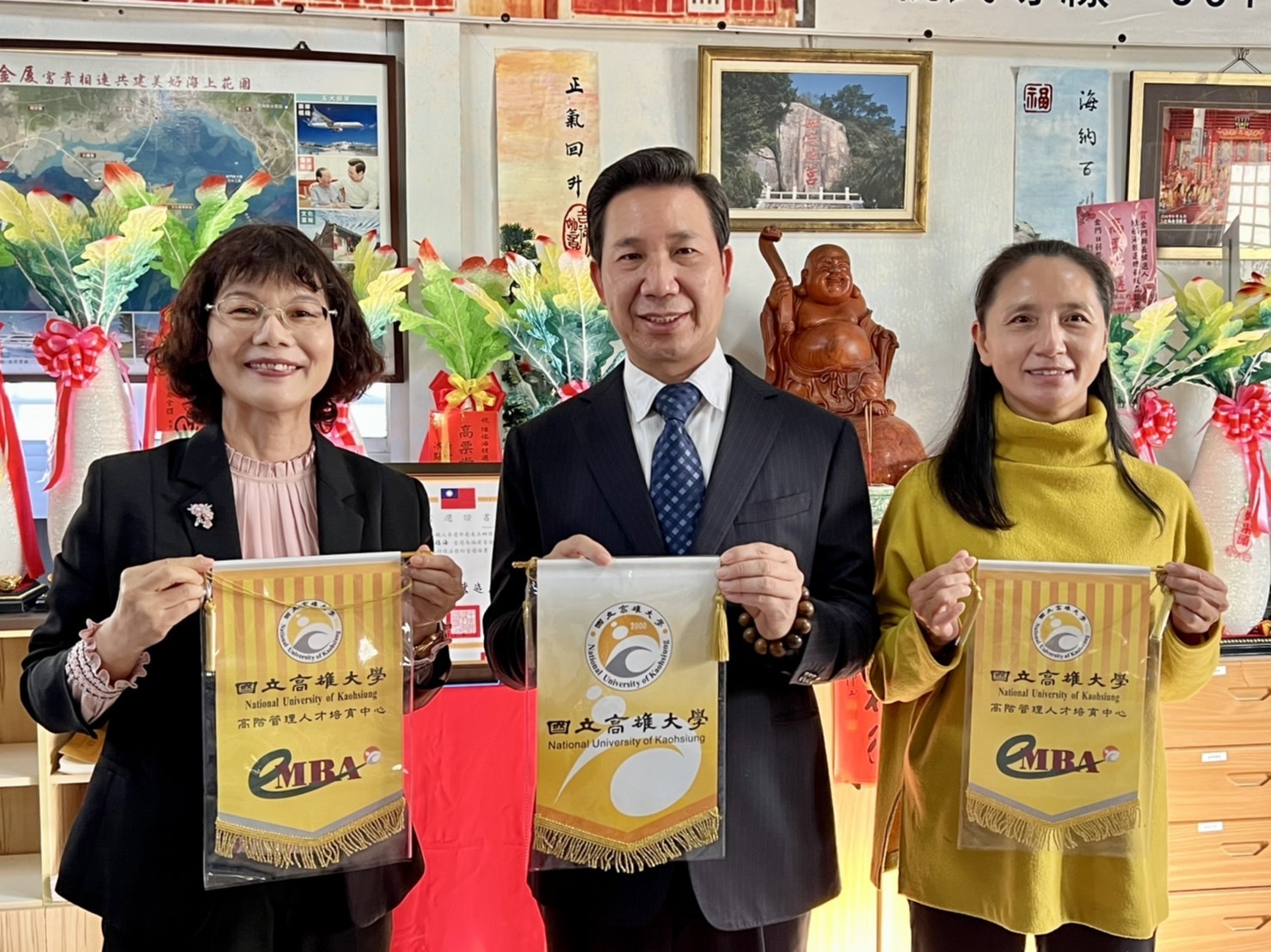 高雄大學校長陳月端（左）致賀、頒贈校旗及系旗予 高雄大學（EMBA）98級畢業校友陳福海。