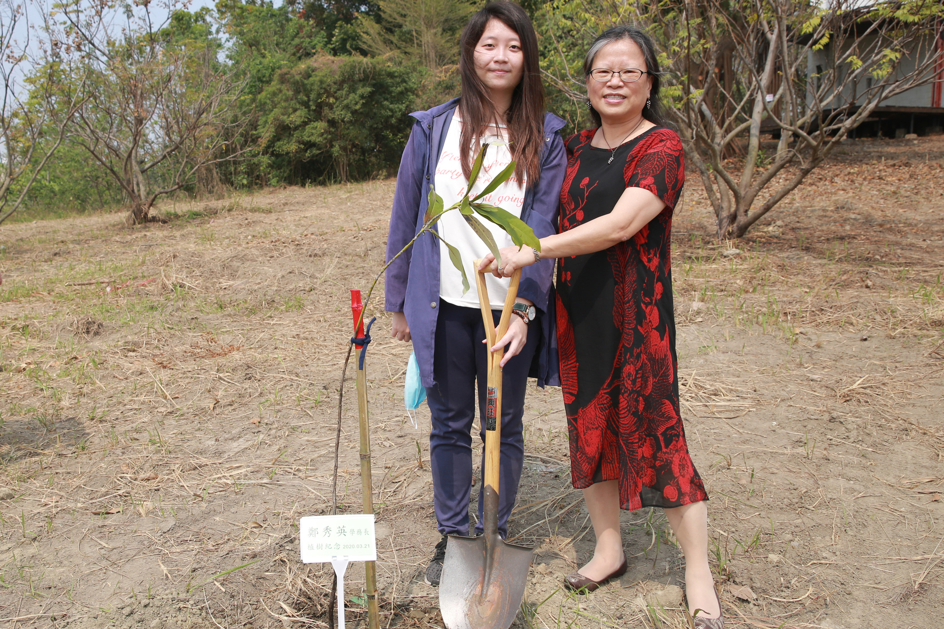 學務長鄭秀英(右)與學生植樹圖片