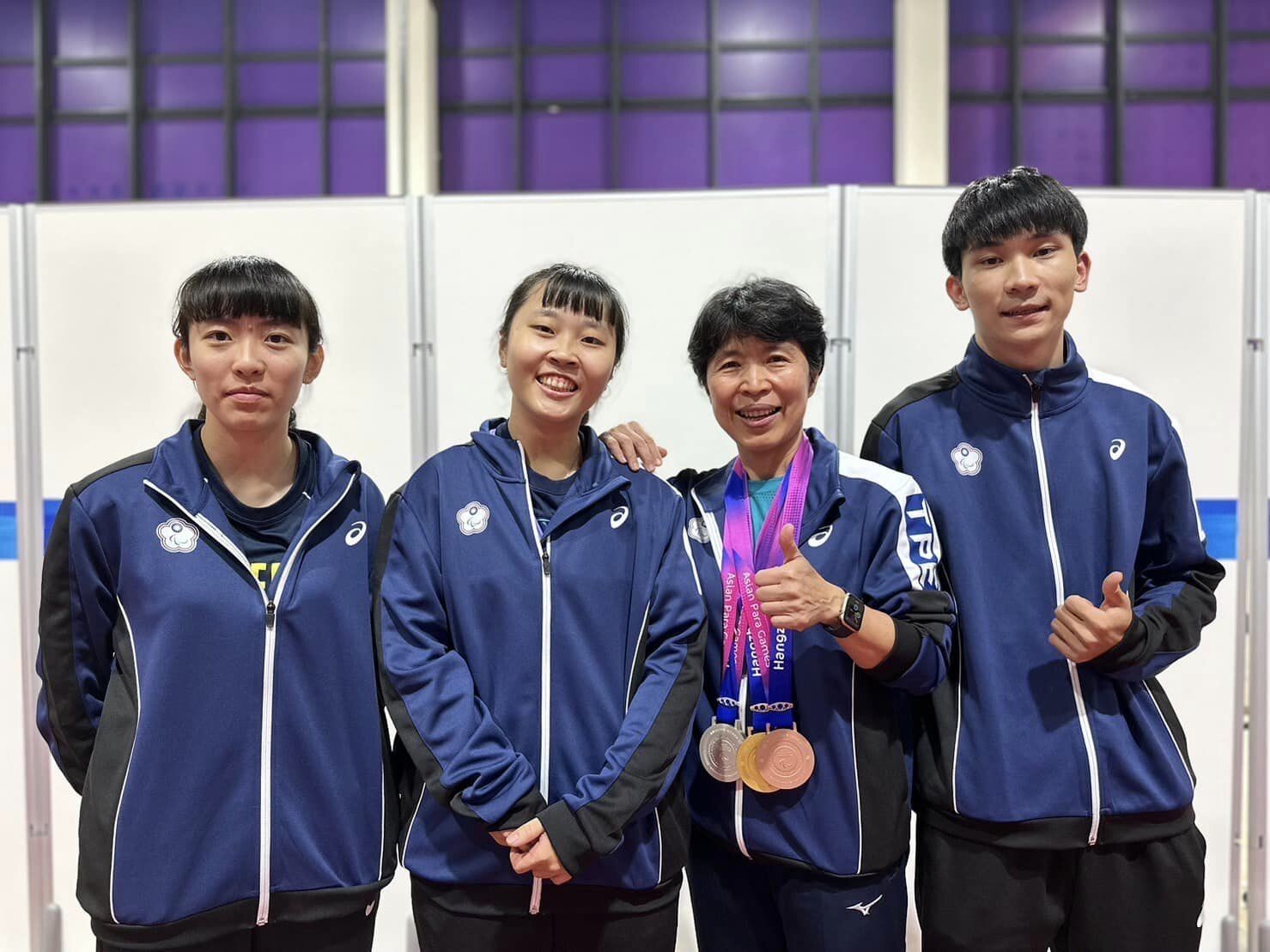 NUK students Lin Tzu-Yu (left1), Tian Shiau-wen (left2), and Su Jin-Sian (right1) achieved gold, silver, and bronze medals at the 2022 4th Hangzhou Asian Para Games. They celebrated their success with a photo alongside their mentor, Wang Ming- Yueh.