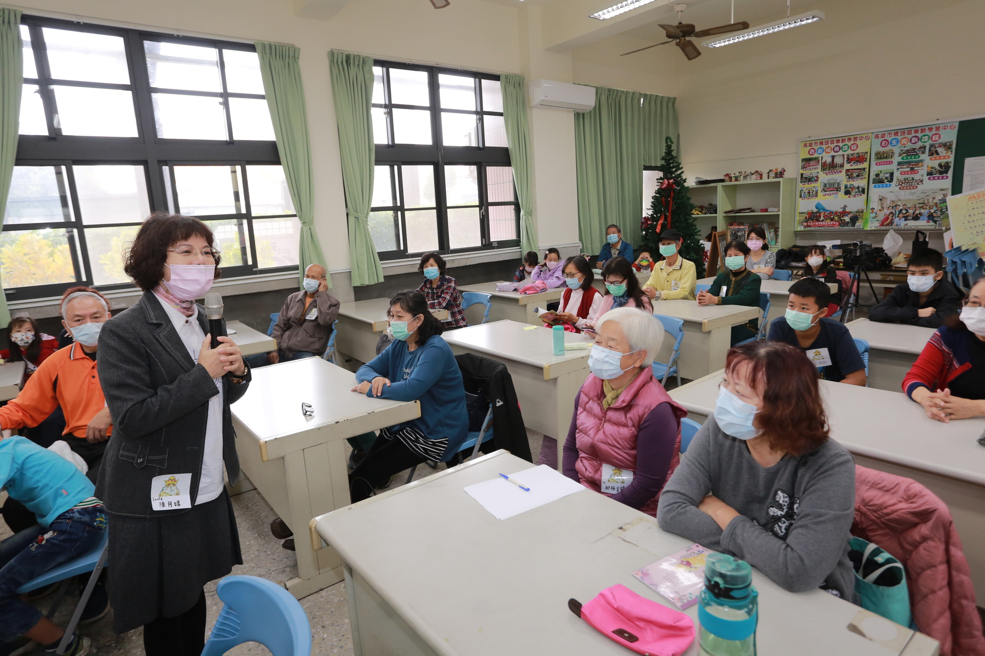 高雄大學校長陳月端(立者)出席疾病敘事祖孫共學營，與長輩、學童寒暄話家常。